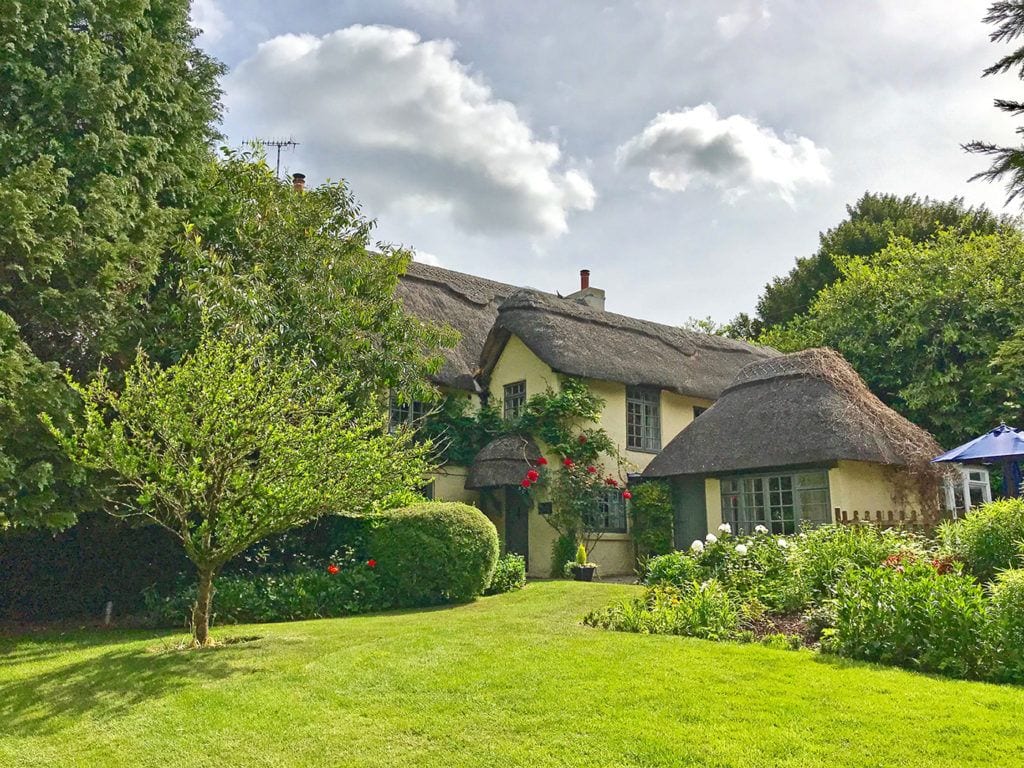Beck Cottage self catering holiday home in the New Forest beautiful roses and wisteria surround this thatch cottage