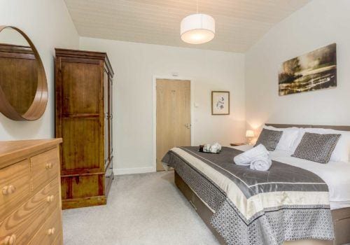 Riverside Lodge bedroom with quirky furniture, neutral colour scheme creating a light and airy atmosphere
