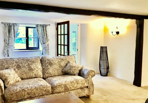 Comfy thatched cottage interior with traditional sofa in Dorset