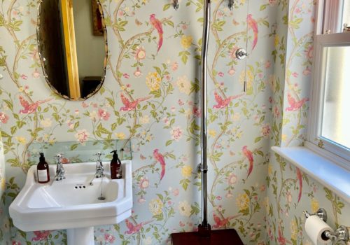 Ground floor cloakroom withy laura Ashley wallpaper and old fashioned toilet cistern