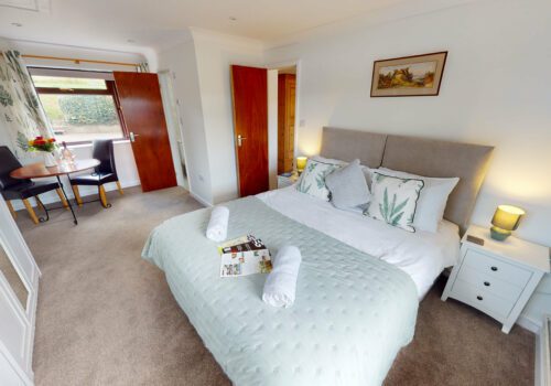 Lovely large bedroom with ensuite nad table and chairs looking out to a paddock in the New Forest